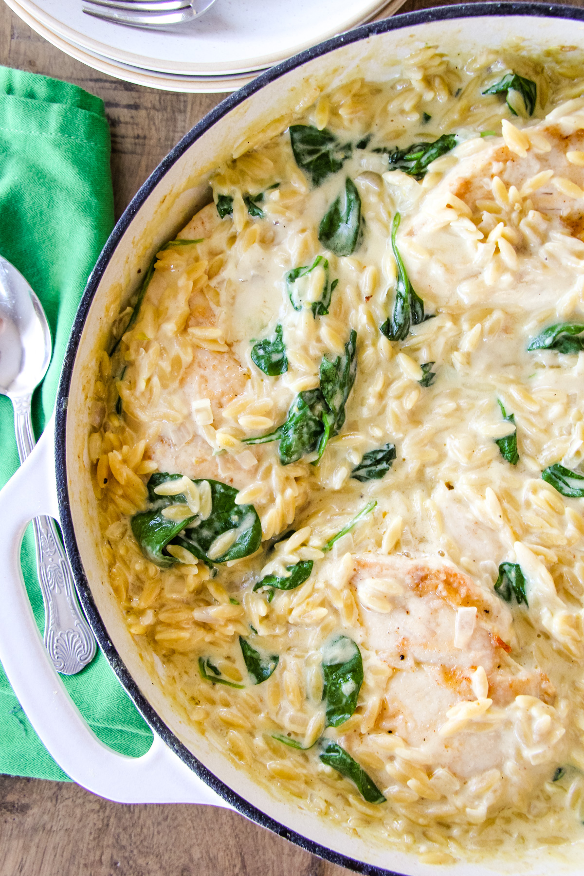 a top down image of a dish of creamy chicken orzo with spinach