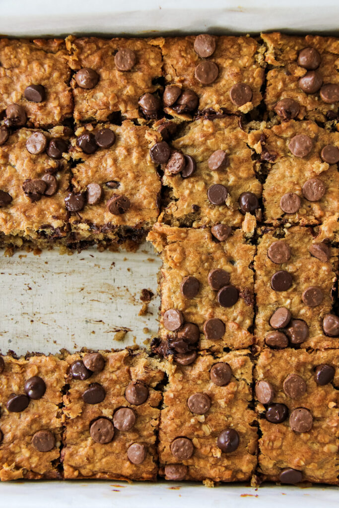 a top down view of a pan of Peanut Butter Chocolate Chip Banana Oatmeal Bars with two missing