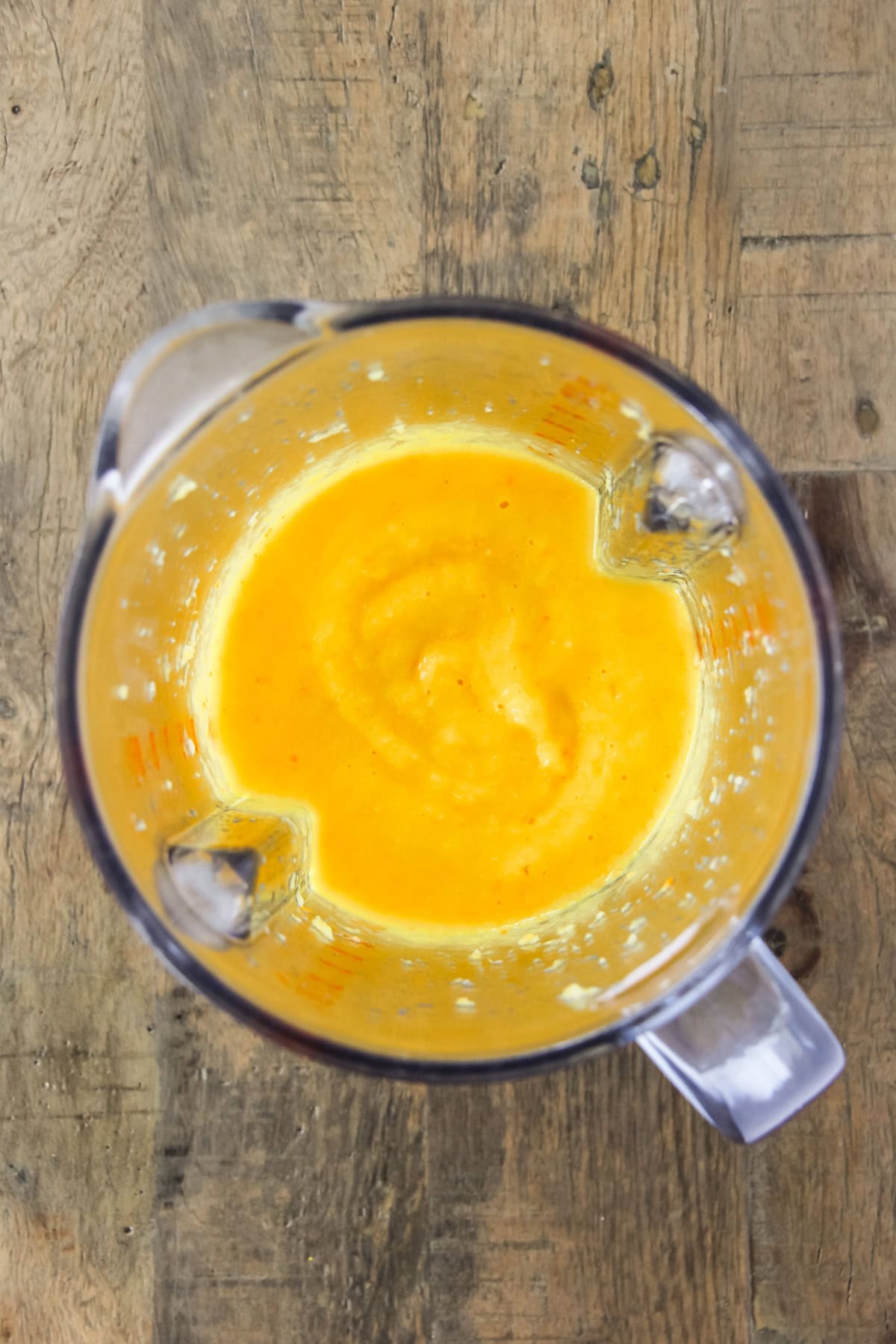 a top down view of a blender filled with pureed oranges