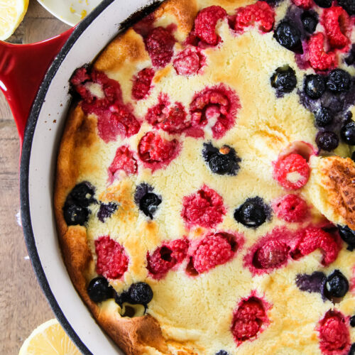 a dutch berry pancake with raspberries and blueberries
