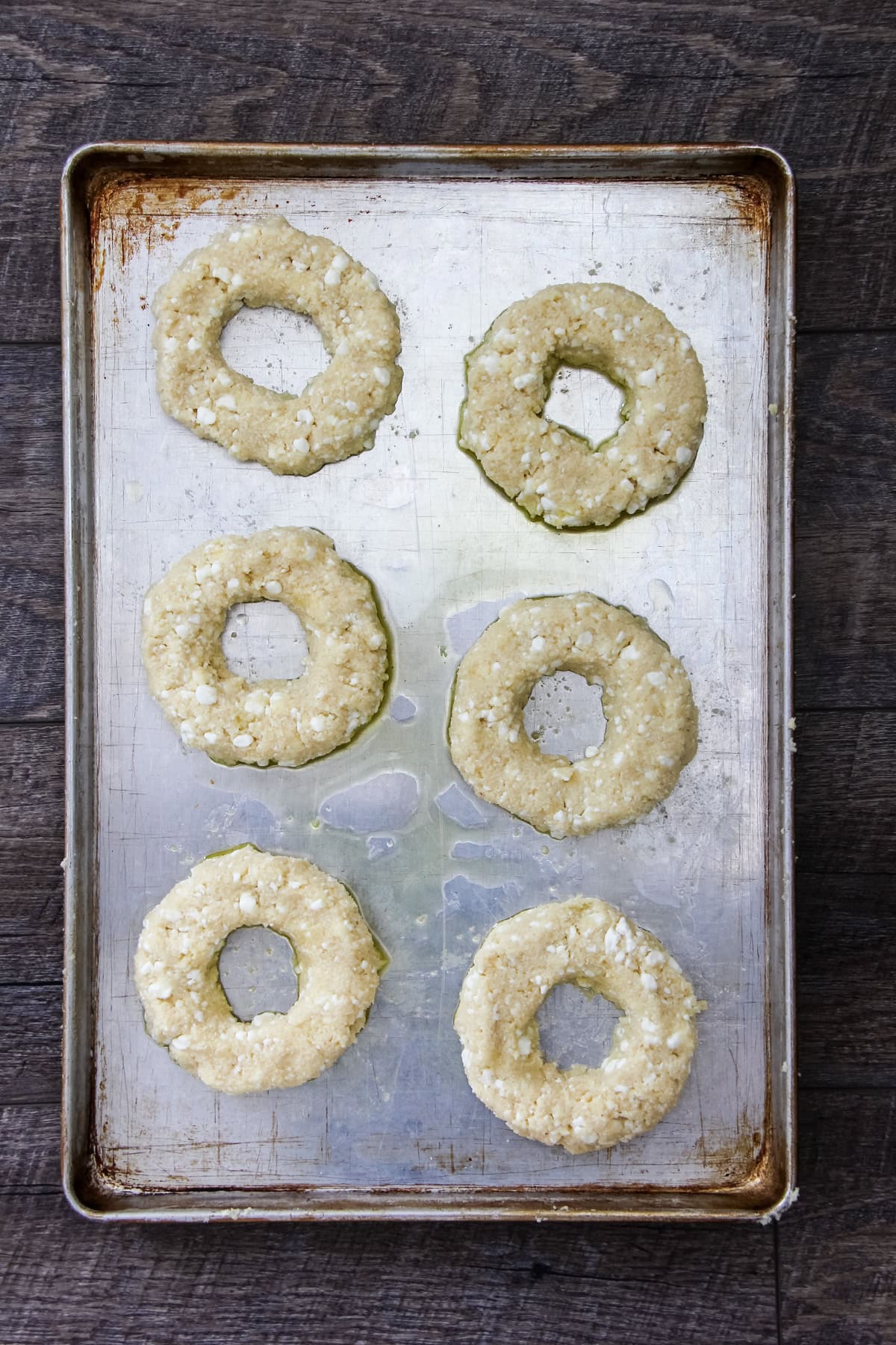 a top down image of unbaked Cottage Cheese Bagels on a baking sheet