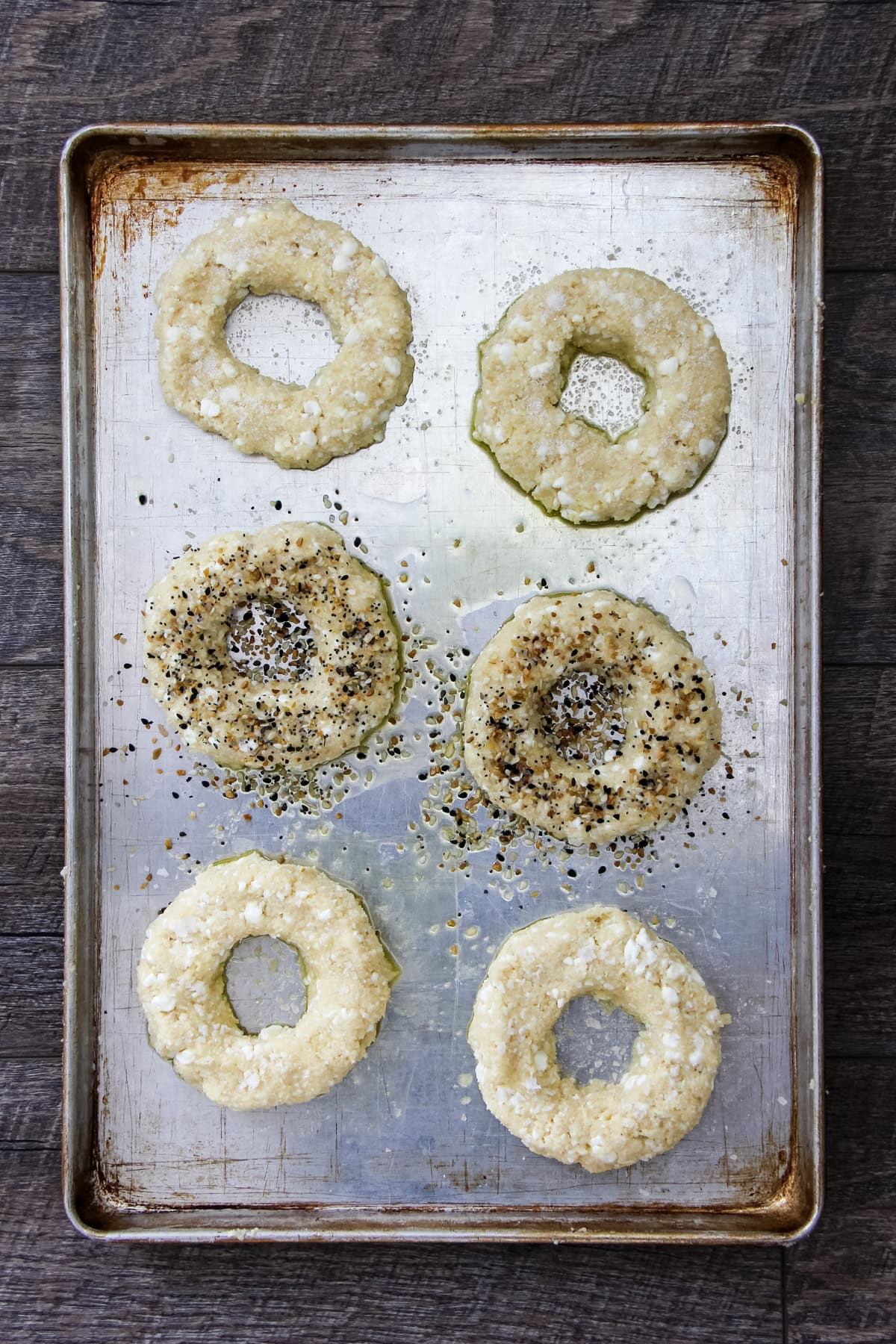 a top down image of unbaked Cottage Cheese Bagels on a baking sheet