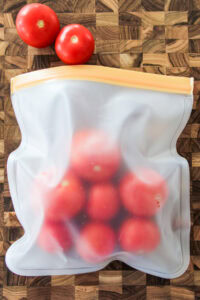 a freezer bag filled with whole tomatoes