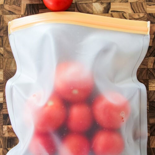 a freezer bag filled with whole tomatoes