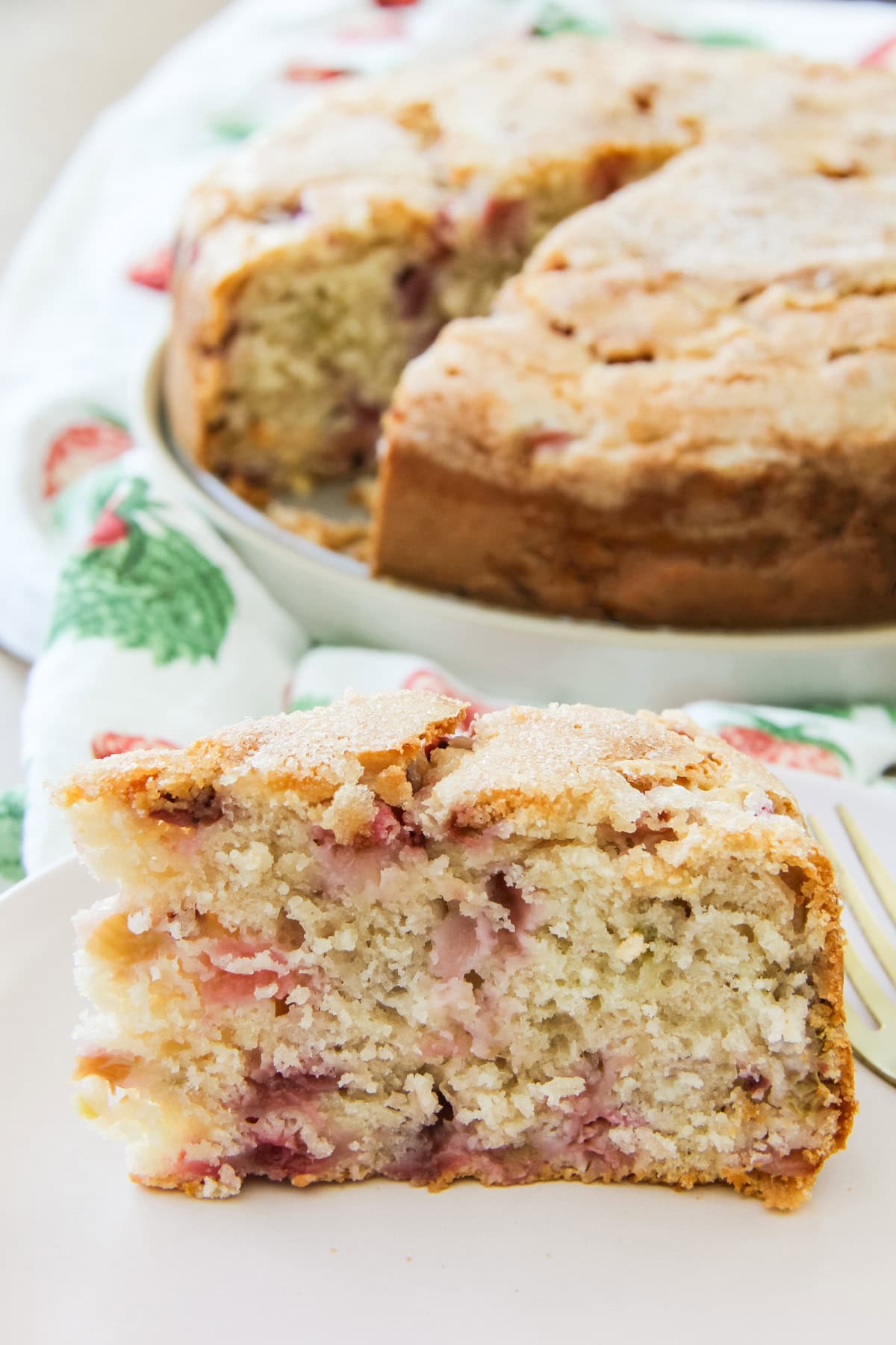 a slice of Strawberry Buttermilk Cake sits on a plate