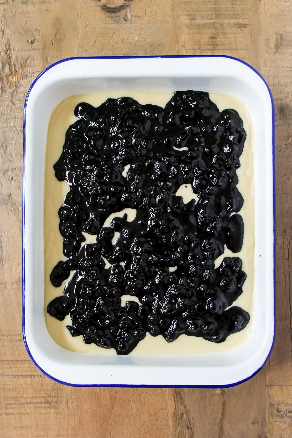 a pan of unbaked blueberry pudding cake